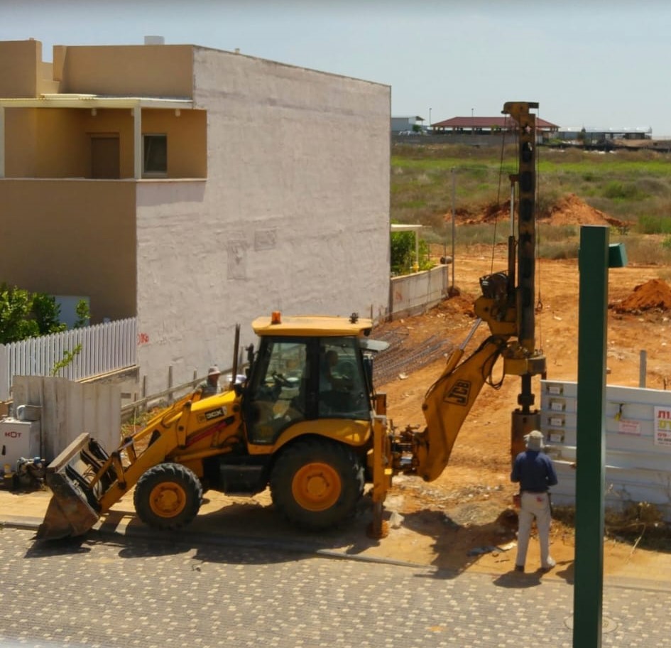 מחפרון קידוח עובד בחצר עם גישה מוגבלת